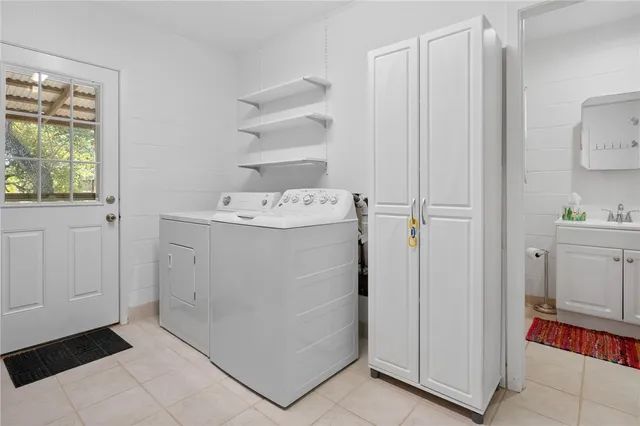 a utility room with cabinets washer and dryer