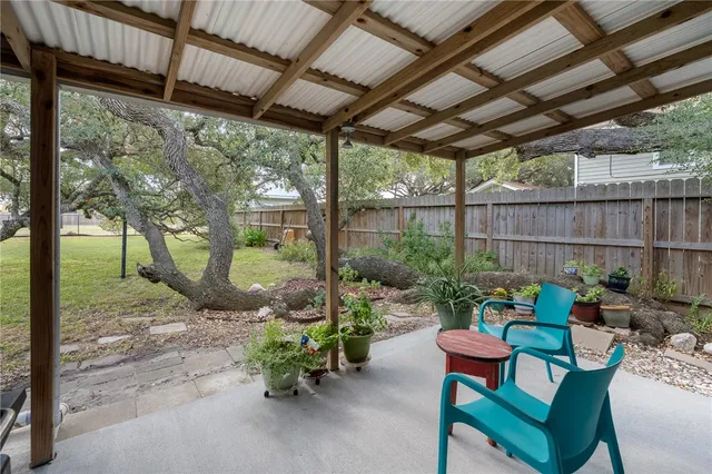a backyard of a house with table and chairs