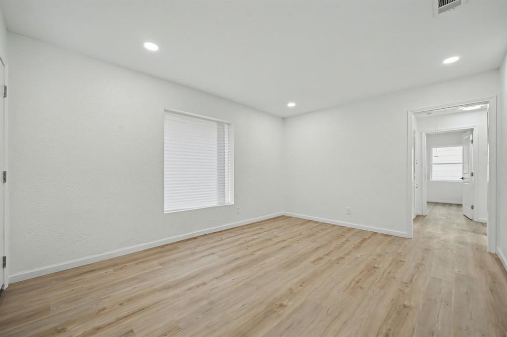 11446 Lippitt Avenue Dallas, TX 75218 - Photo 12 of 26 a view of an empty room with wooden floor and a window
