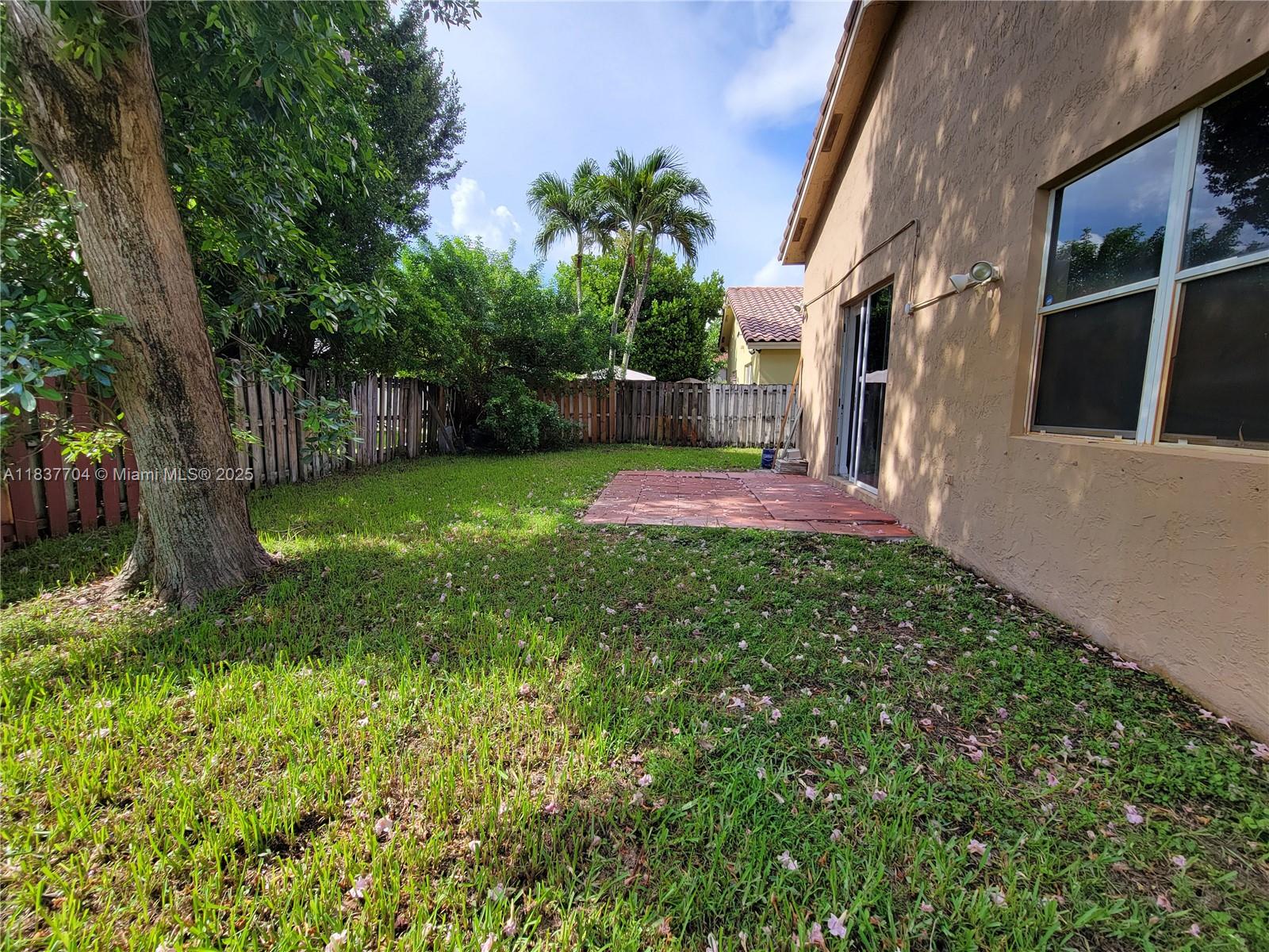 Miramar Patio Homes Miramar, FL 33027 - Photo 43 of 43 a view of a backyard with potted plants and large tree