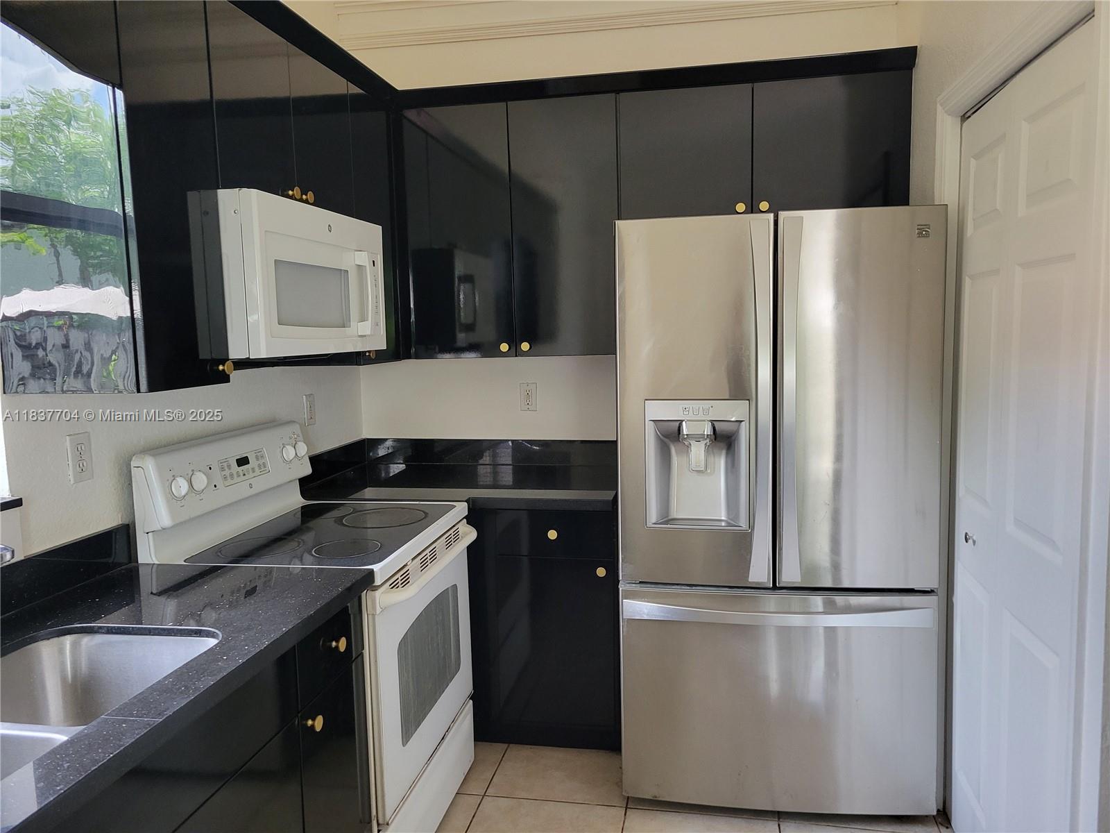 Miramar Patio Homes Miramar, FL 33027 - Photo 6 of 43 a kitchen with a refrigerator sink and microwave