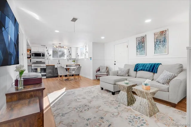 a living room with furniture and view of kitchen