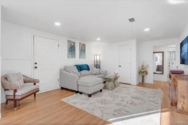 a living room with furniture and a wooden floor