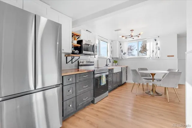a kitchen with stainless steel appliances granite countertop a refrigerator and a stove top oven