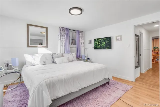 a bedroom with a bed and a painting on the wall