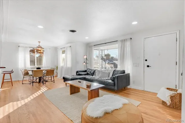 a living room with furniture wooden floor and a window