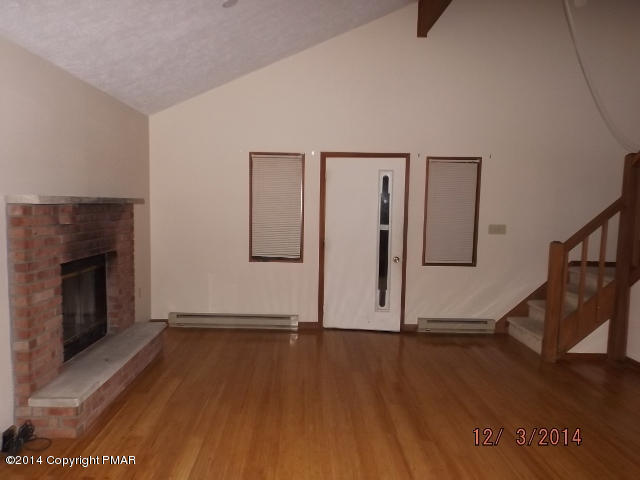 833 Canterbury Road Bushkill, PA 18324 - Photo 4 of 9 a view of empty room with wooden floor and fireplace