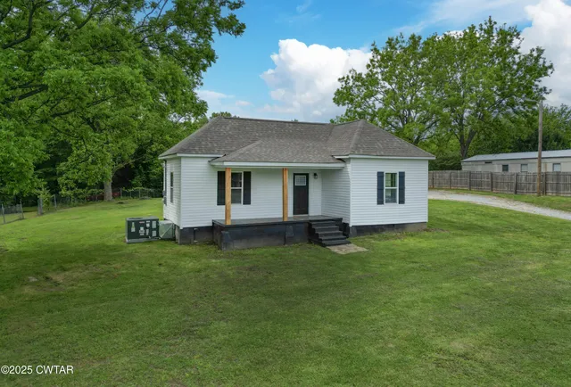 a backyard of a house with table and chairs