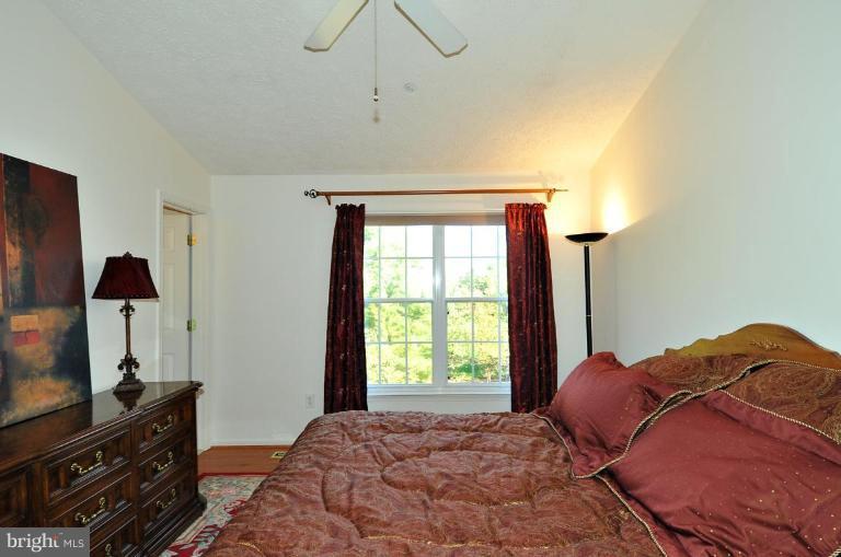 6116 Starburn Path Columbia, MD 21045 - Photo 6 of 18 a bedroom with a bed and a flat tv screen on a dresser