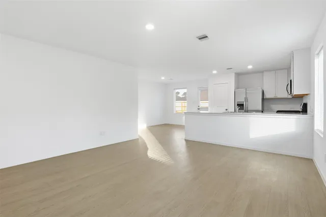 a view of a kitchen with kitchen island and stainless steel appliances