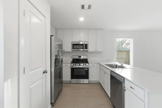 a kitchen with a sink stove and refrigerator