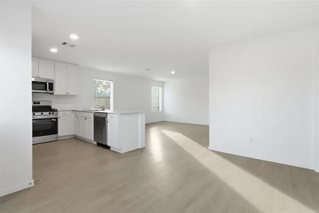 a kitchen with a refrigerator and a stove top oven