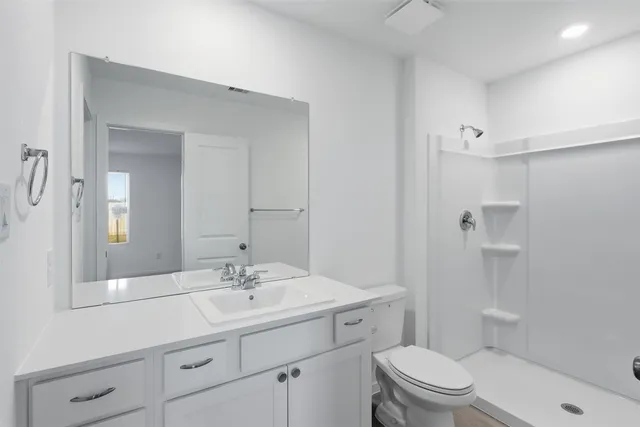 a bathroom with a sink toilet a mirror and shower