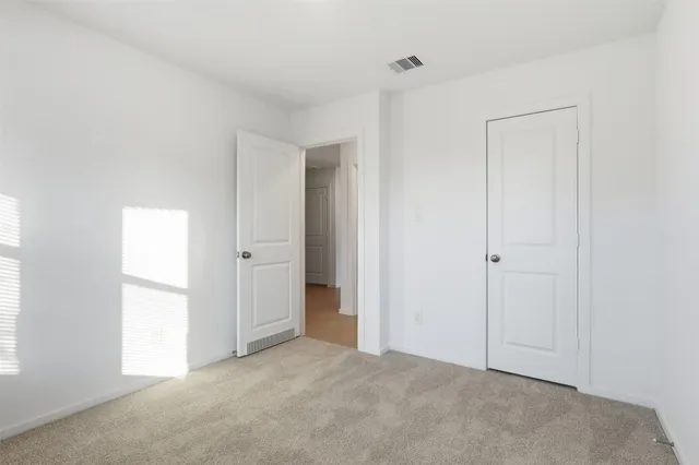 an empty room with windows and closet