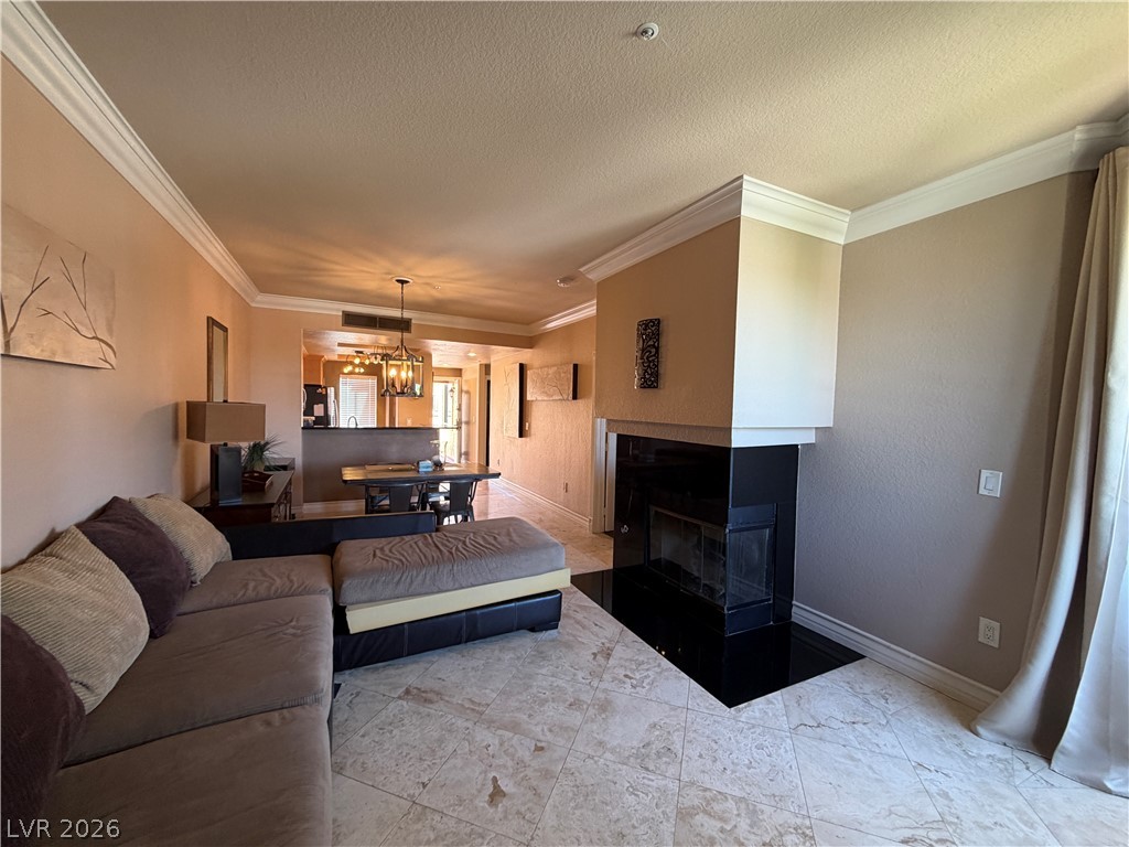 210 East Flamingo Road, Unit 426 Las Vegas, NV 89169 - Photo 7 of 17 Elegant crown molding complements a sophisticated fireplace and a dining area, creating a polished living space.
