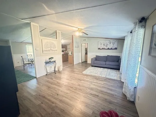 a view of a hallway with wooden floor and furniture