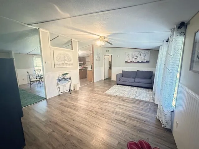 a view of a hallway with wooden floor and furniture