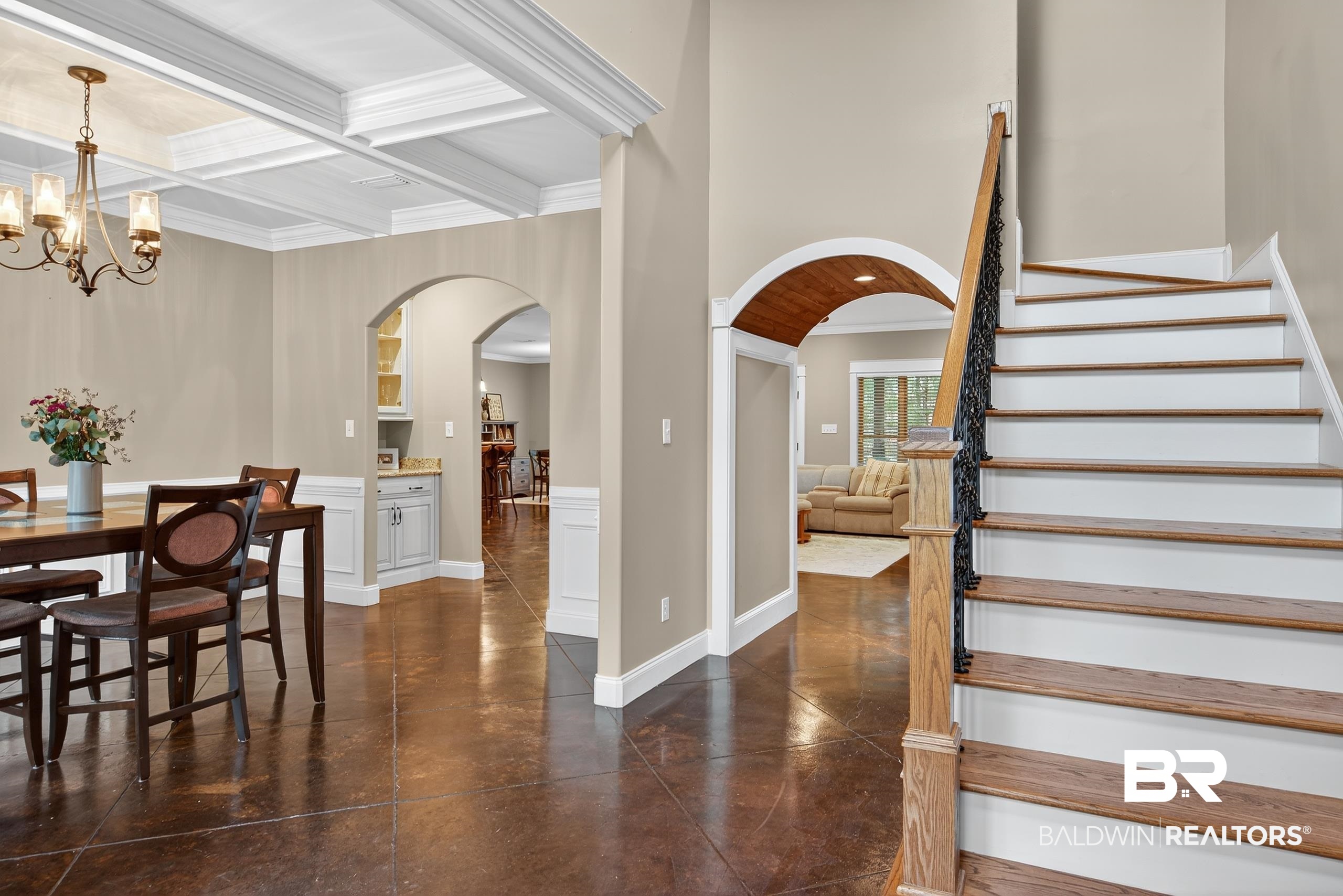 5517 Rabbit Creek Drive Theodore, AL 36582 - Photo 10 of 33 Welcoming foyer that opens into multiple areas, including the dining space on the left, a living room straight ahead, and the staircase leading to the upper level. The arched doorways and coffered ceiling give it a polished, upscale feel.