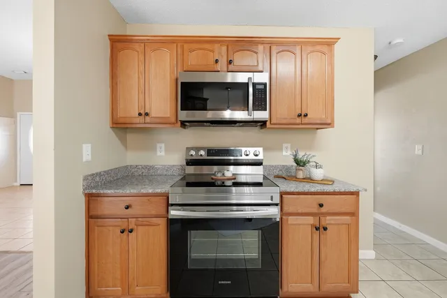 a kitchen with stainless steel appliances granite countertop a stove microwave and sink