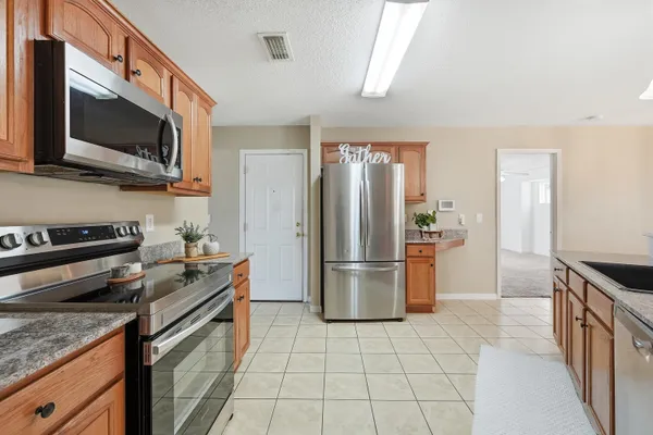 a kitchen with a stove a refrigerator and a microwave