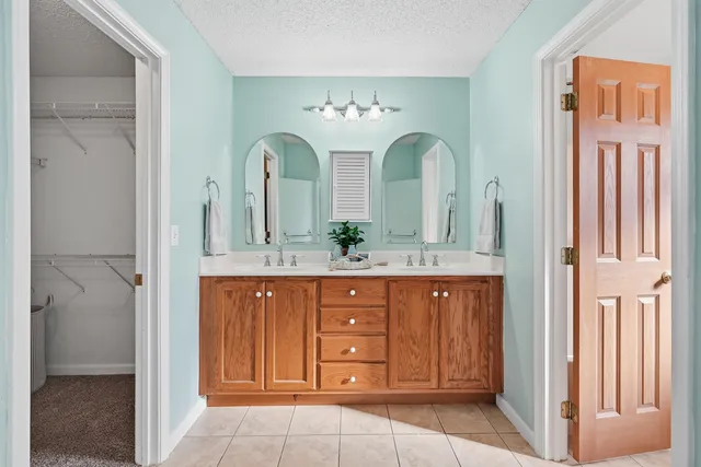 a spacious bathroom with a double vanity sink and a mirror