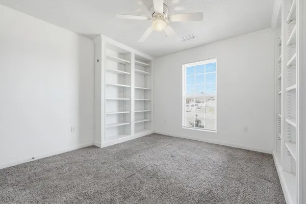 an empty room with a empty shelves and natural light