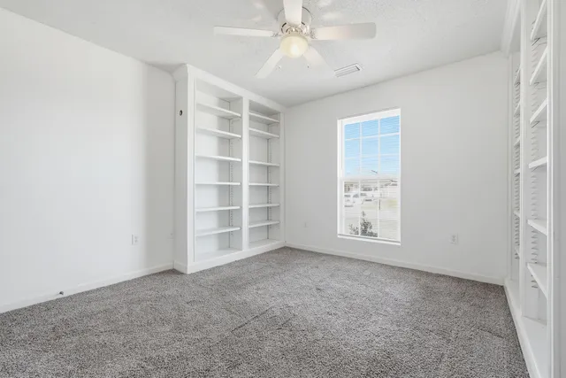 an empty room with a empty shelves and natural light