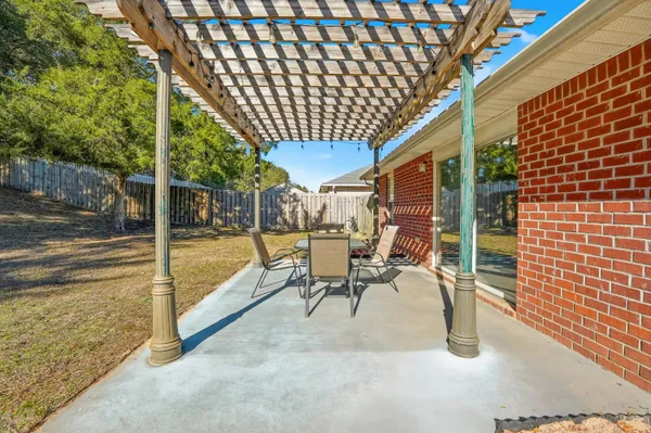 a view of a patio with table and chairs with wooden floor and fence