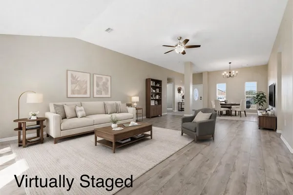 a living room with furniture or chandelier and a wooden floor