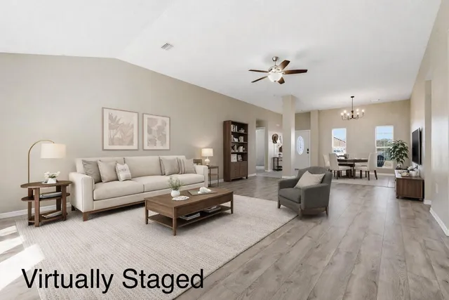 a living room with furniture or chandelier and a wooden floor