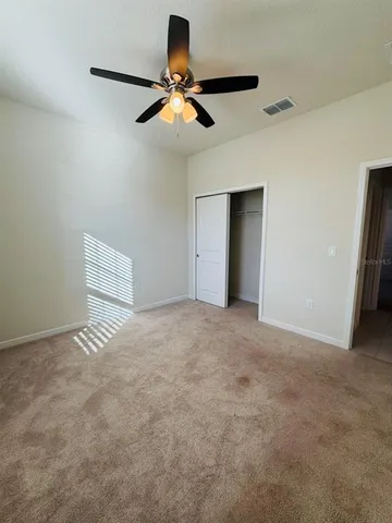 a view of an empty room with a ceiling fan