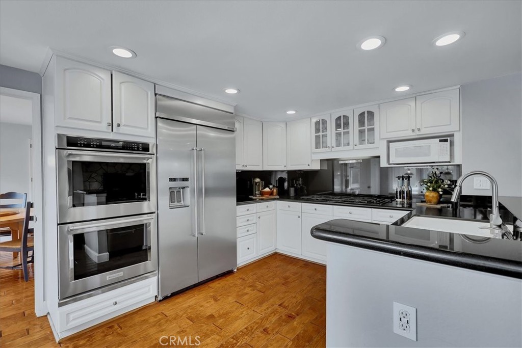 22 Colonial Irvine, CA 92620 - Photo 10 of 47 a kitchen with stainless steel appliances a stove a sink a microwave and cabinets