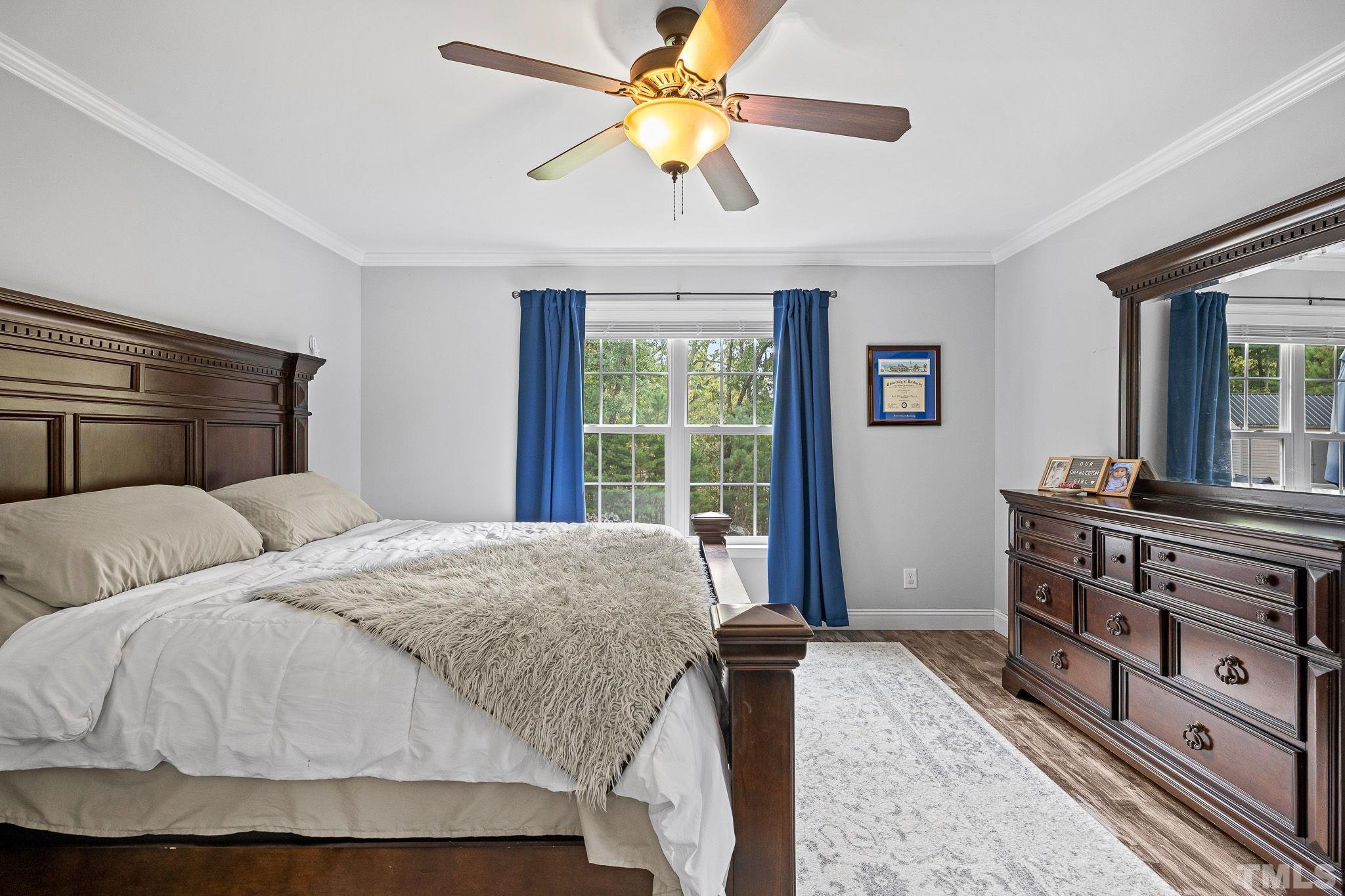 7405 Buckingham Mountain Road Snow Camp, NC 27349 - Photo 11 of 26 a bedroom with a bed and a dresser with wooden floor