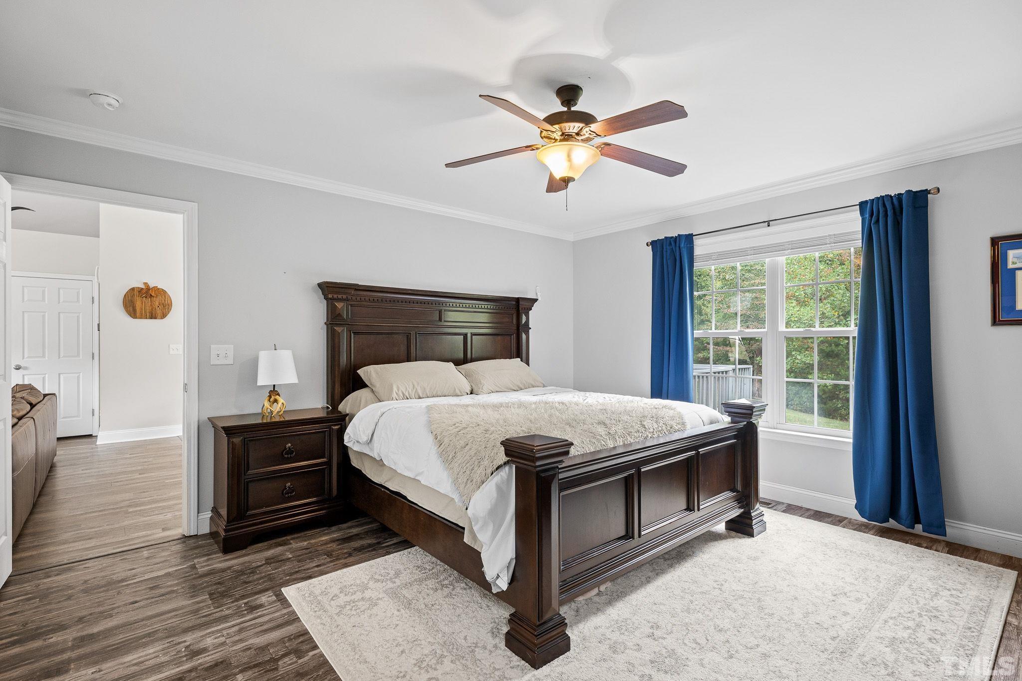 7405 Buckingham Mountain Road Snow Camp, NC 27349 - Photo 13 of 26 a bedroom with a bed and a chandelier