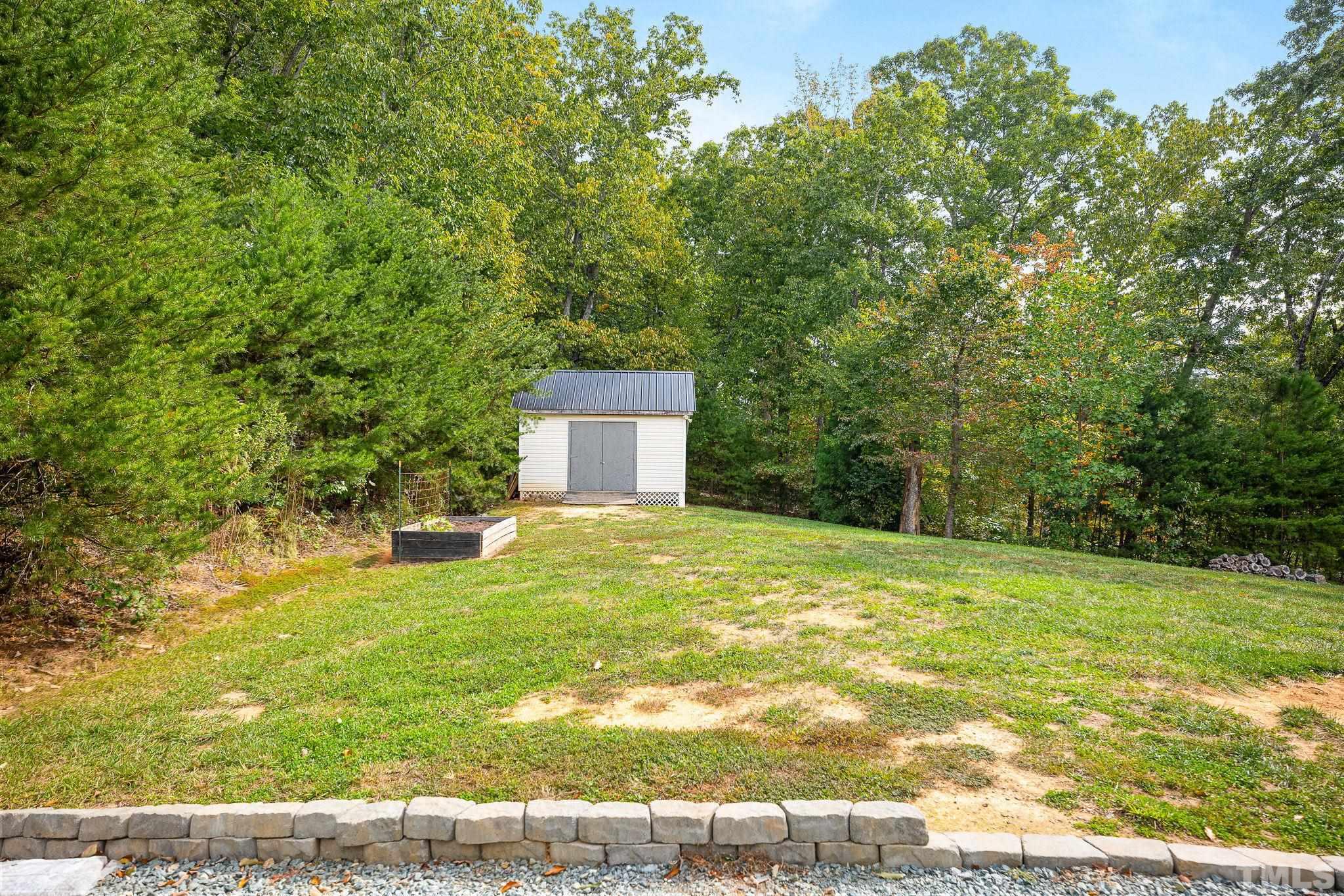 7405 Buckingham Mountain Road Snow Camp, NC 27349 - Photo 22 of 26 a house with trees in the background