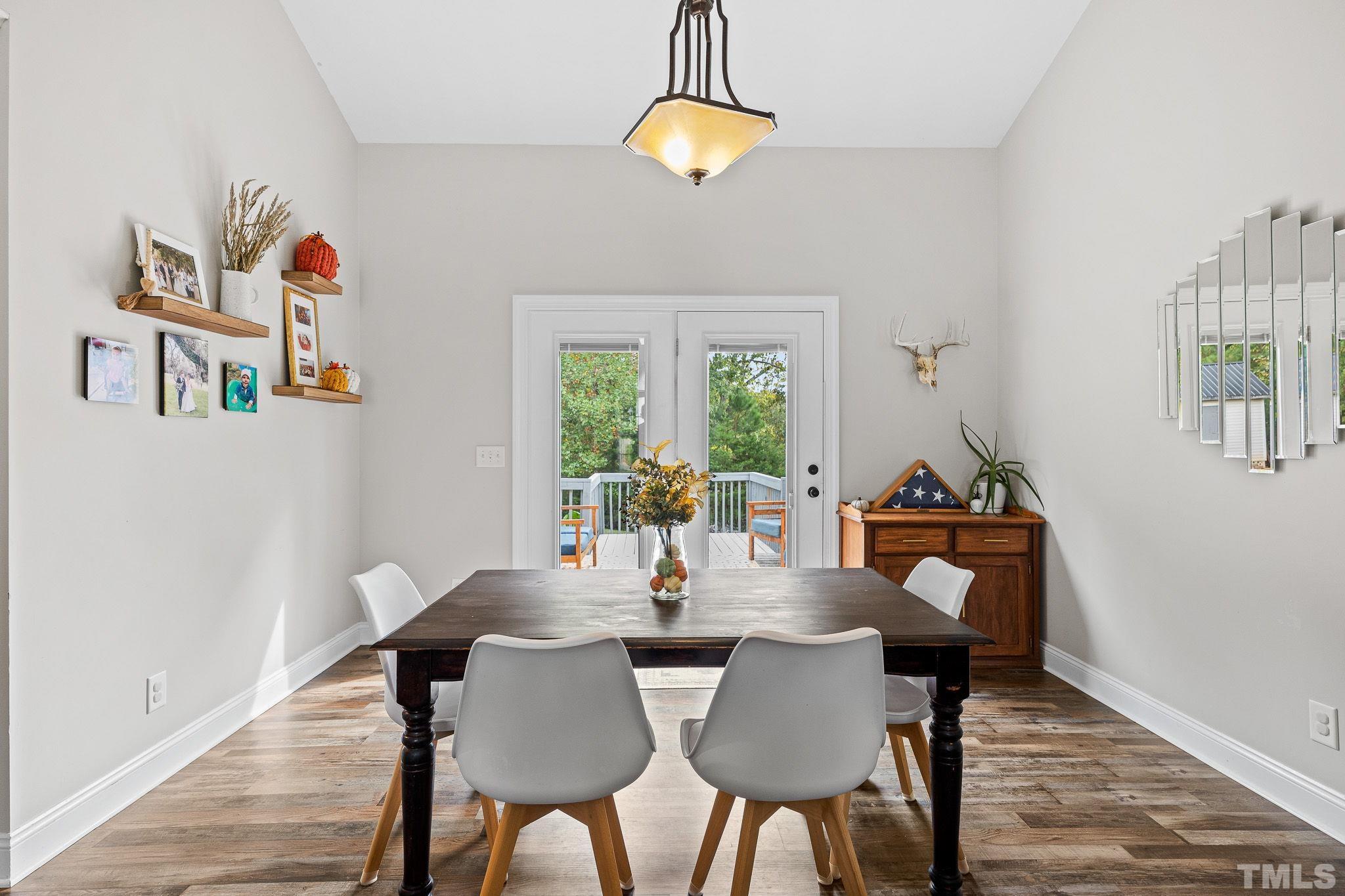 7405 Buckingham Mountain Road Snow Camp, NC 27349 - Photo 6 of 26 a view of a dining room with furniture a chandelier and wooden floor