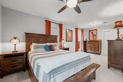 a bedroom with a bed and dresser with chair