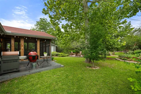 a view of a chair and table in backyard of the house