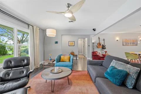 a living room with furniture a rug and a large window