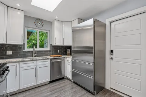 a kitchen with a refrigerator and white cabinets