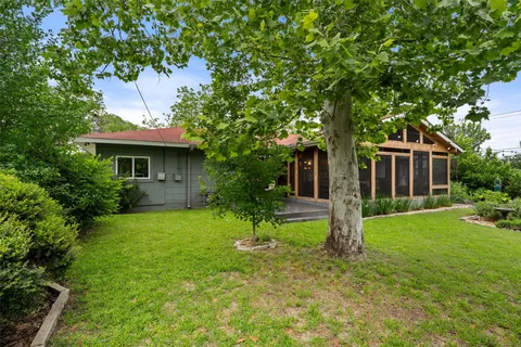 a front view of a house with a yard and trees
