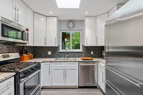 a kitchen with stainless steel appliances a stove sink microwave and cabinets