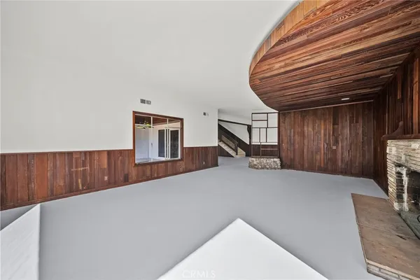 a view of staircase with lots of frames on wall and wooden floor