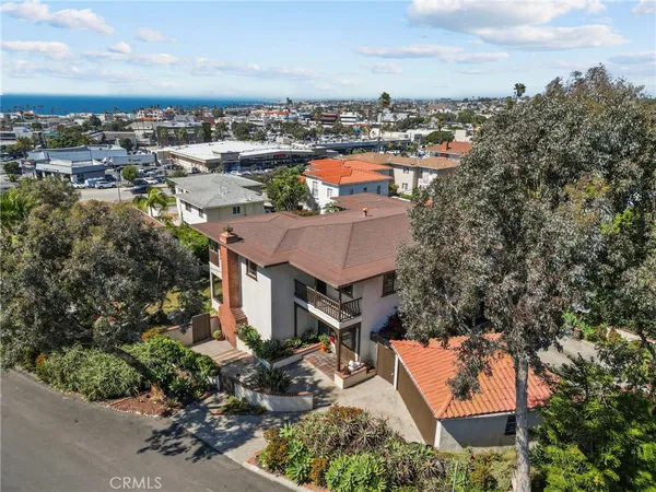 an aerial view of residential houses with outdoor space and trees