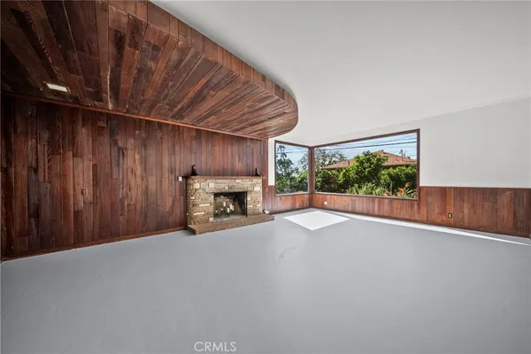 a view of an empty room with a fireplace and a window