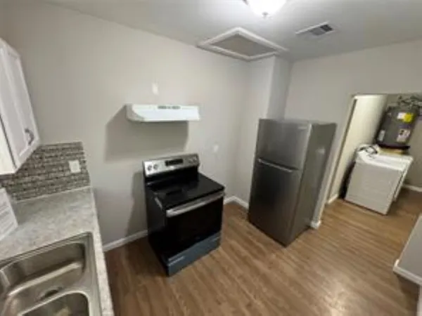 a kitchen with stainless steel appliances granite countertop a refrigerator and a stove