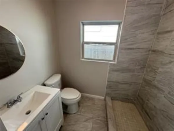 a white toilet sitting next to a bathroom sink