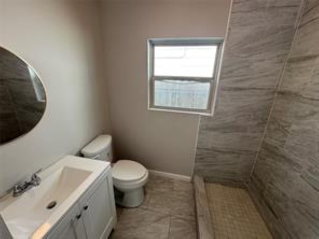 3231 Holman Street Houston, TX 77004 - Photo 5 of 6 a white toilet sitting next to a bathroom sink