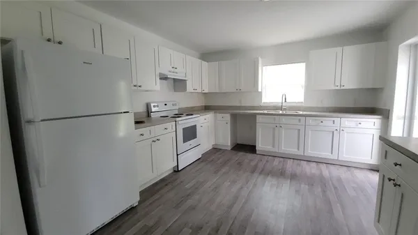 a kitchen with white cabinets and white appliances