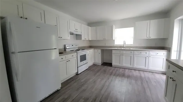 a kitchen with white cabinets and white appliances